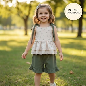 K&ouml;nnte beinhalten: Ein zweiteiliges Kinderoutfit. Das Oberteil ist cremefarben mit floralem Muster und gr&uuml;nen Tr&auml;gern. Die Shorts sind olivgr&uuml;n mit R&uuml;schensaum. Im Hintergrund ist der Text "INSTANT DOWNLOAD" zu sehen.