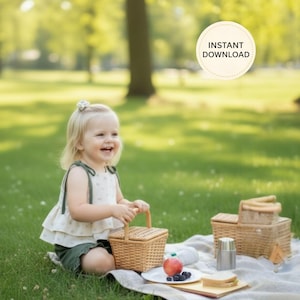 K&ouml;nnte beinhalten: Ein Kind sitzt l&auml;chelnd auf einer Decke in einem Park und h&auml;lt einen kleinen Picknickkorb aus Weide. Ein Teller mit Essen, eine Thermoskanne und ein Spielzeug-LKW befinden sich in der N&auml;he. Das Bild hat eine weiche, nat&uuml;rliche Beleuchtung mit unscharfem Hintergrund.