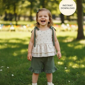 K&ouml;nnte beinhalten: Ein zweiteiliges Kinderoutfit. Das Oberteil ist cremefarben mit floralem Muster und gr&uuml;nen Tr&auml;gern. Die Shorts sind olivgr&uuml;n mit R&uuml;schensaum. Das Bild enth&auml;lt eine runde Grafik mit "INSTANT DOWNLOAD".