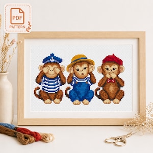 May include: Cross-stitch pattern of three cartoon monkeys in a wooden frame. One monkey covers its eyes, another its ears, and the third its mouth. Each monkey wears different clothing: a sailor outfit, overalls, and a beret. The top left corner has a "PDF PATTERN" label.