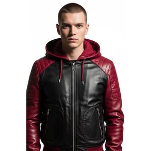 Könnte beinhalten: Eine schwarze und weinrote Lederjacke mit Kapuze. Die Jacke hat ein gestepptes Design an Schultern und Ärmeln, einen durchgehenden Reißverschluss und zwei Vordertaschen. Die Kapuze ist weinrot und der Körper der Jacke ist schwarz.
