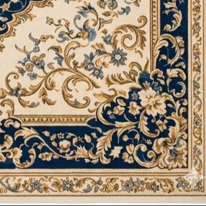 May include: A rectangular area rug featuring a cream-colored background with a deep blue border. The design includes intricate gold and blue floral patterns, scrolling vines, and acanthus leaf motifs that create a symmetrical, ornate composition.
