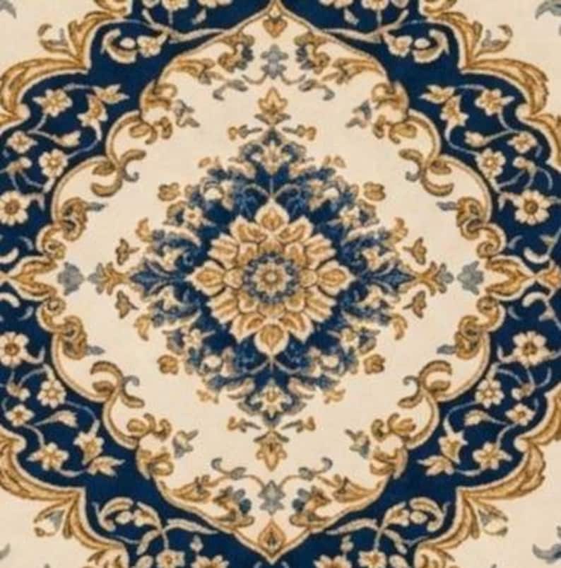 May include: A rug featuring a symmetrical, intricate floral pattern in deep navy blue, cream, and golden tan. The design centers on a large, ornate medallion surrounded by scrolling vines, leaves, and small blossoms, creating a repeating motif.