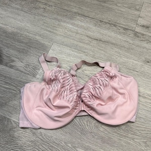 Könnte beinhalten: Ein hellrosa BH mit verstellbaren Trägern und einem Frontverschluss. Die Körbchen sind einfarbig rosa mit einem dekorativen Spitzeneinsatz. Der BH ist auf Halt und Komfort ausgelegt.