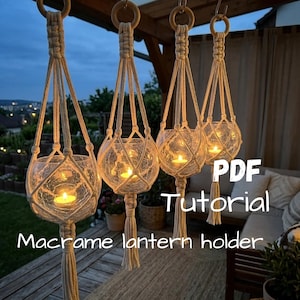 Può includere: Quattro portalanterne in macramè sospesi realizzati in corda color bianco sporco, ciascuno dotato di una ciotola rotonda in vetro craquelé con all'interno un lumino acceso. Ogni supporto è appeso a un anello di legno e rifinito con una nappa. Testo: PDF Tutorial Macrame lantern holder.