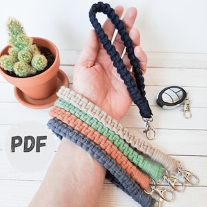 May include: A collection of macrame wrist lanyards in various colors, including navy blue, peach, green, and beige. Each lanyard features a silver-tone clasp. A navy blue lanyard is held up, and the word "PDF" is visible.