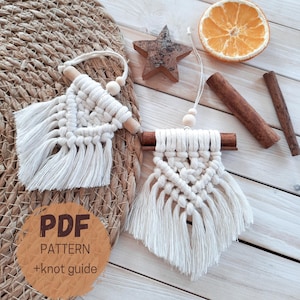Op de afbeelding: Twee handgemaakte macramé wandkleden met houten deuvels en franjes. De afbeelding bevat een stervormig houten ornament, een gedroogde sinaasappelschijf, kaneelstokjes en een ronde sticker met de tekst "PDF PATTERN +knot guide".