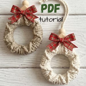 May include: Two circular ornaments made of wrapped yarn, one in tan and one in off-white, each featuring a red and green plaid ribbon bow, a wooden bead, and a hanging cord. The text PDF tutorial is visible in green and black lettering.