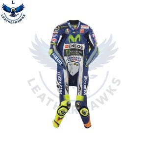 Könnte beinhalten: Blau-weißer und gelber Rennanzug mit Sponsorenlogos, darunter "ENEOS" und "Monster Energy". Der Anzug hat ein "VR46"-Logo und "Yamaha"-Branding. Der Anzug ist für Motorradrennen konzipiert.