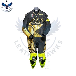 Könnte beinhalten: Schwarzer und goldener Motorrad-Rennanzug mit der Nummer 46. Der Anzug hat gelbe Akzente an Knien und Ärmeln sowie Sponsorenlogos. Der Anzug ist für Schutz und Geschwindigkeit konzipiert.