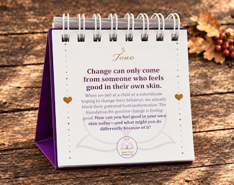 May include: A white desk calendar with a purple base and spiral binding, displaying the date June 5. The page features the text: Change can only come from someone who feels good in their own skin, followed by a paragraph and a question about self-reflection.