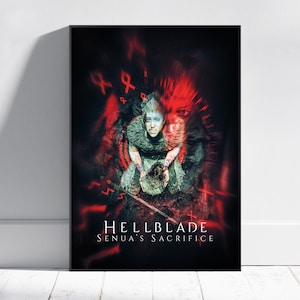 May include: A framed poster featuring a digital illustration from the video game "Hellblade: Senua's Sacrifice." The artwork depicts a woman with blue face paint, a fur collar, and a dark background with red accents and text.