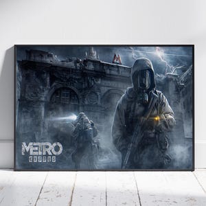 May include: A framed poster featuring the "Metro Exodus" video game. The artwork depicts two figures in gas masks and protective gear, holding rifles, against a backdrop of a ruined cityscape. The poster has a dark, atmospheric color palette.