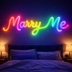 以下が含まれることがあります： 暗い壁に「Marry Me」と書かれた虹色のネオンサインが、ベッドの上に飾られています。サインは赤から紫へのグラデーションで照らされています。ベッドには枕と掛け布団があり、両側にランプがあります。