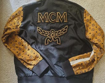MCM Lederjacken : Luxuriöse MCM Collaboration Bomberjacke in Schwarz & Cognac-Monogramm-Ärmeln, Streetwear-Stil