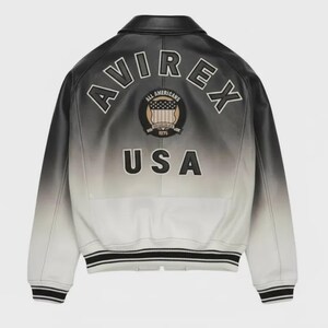 May include: A black and white gradient leather bomber jacket featuring the text AVIREX in an arc, a circular All Americans 1975 patch with a shield graphic, and the text USA in large black letters on the back, with striped ribbed cuffs and hem.