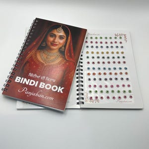 May include: A spiral-bound Bindi Book with a cover featuring a woman in traditional Indian attire. The open book reveals sheets of colorful bindis in various colors and designs, perfect for cultural celebrations.