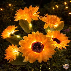 May include: Illuminated artificial sunflowers with bright orange petals and dark brown centers. The solar-powered flowers are lit with warm white lights, creating a glowing effect. The image shows several sunflowers in a garden setting.