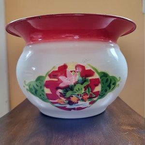 May include: White enamel planter with a red rim and a floral design featuring a pink flower, green leaves, and a red and yellow double happiness symbol.