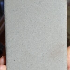 May include: A gray, rectangular, textured coaster.