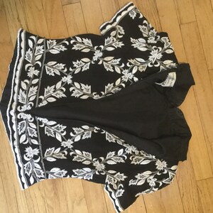 Puede incluir: Top de manga corta negro y blanco bordado con un patr&oacute;n floral.