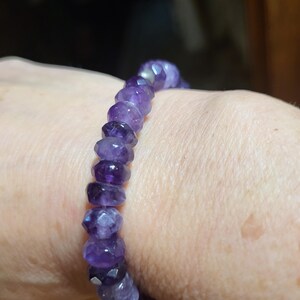 May include: A purple amethyst gemstone bracelet with faceted beads.