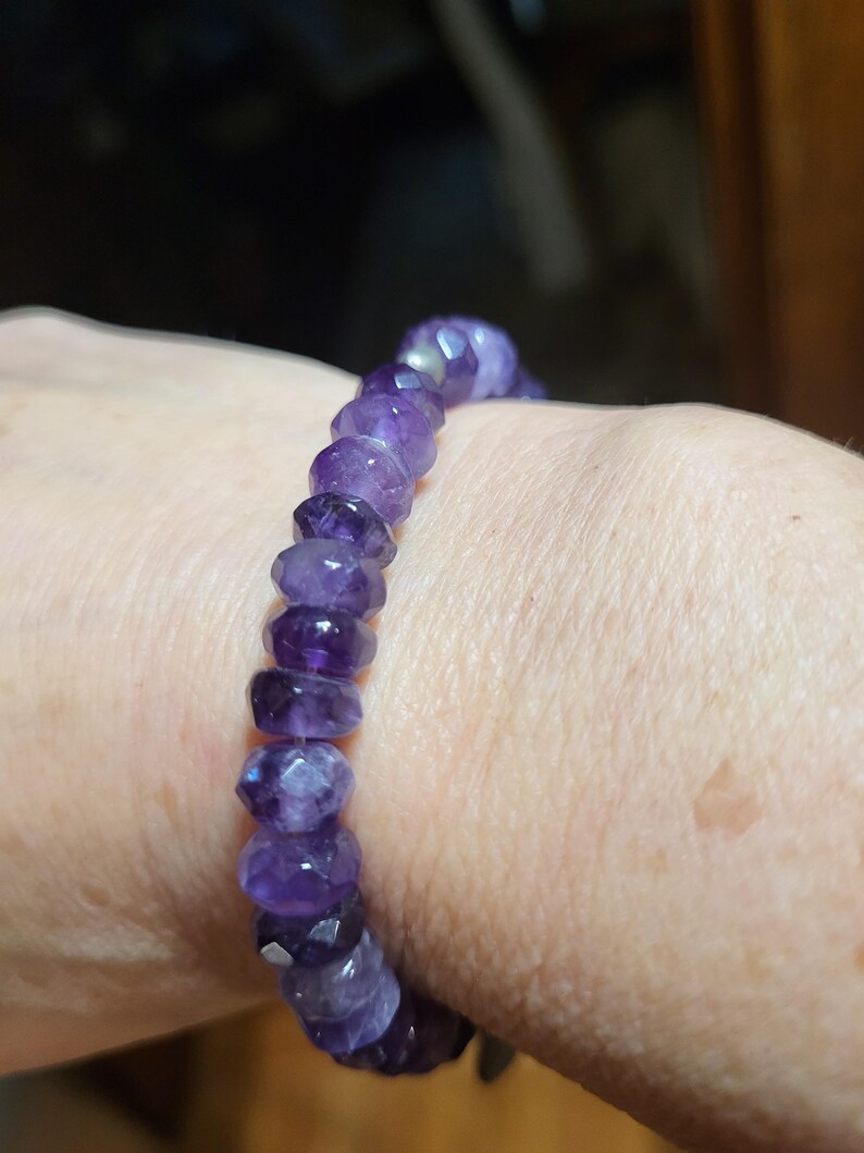 May include: A purple amethyst gemstone bracelet with faceted beads.