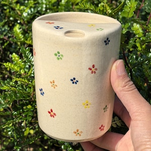 May include: A white ceramic mug with a black handle and the text "But First, Coffee" in a handwritten style. The mug is on a white surface. The mug is 4 inches tall.