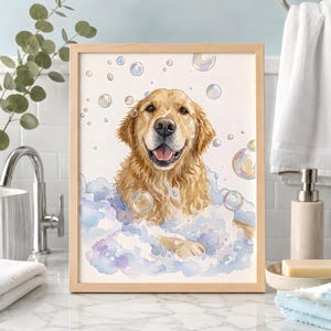 May include: A framed watercolour illustration of a golden retriever dog with a happy expression, surrounded by light blue and purple soap bubbles. The dog is depicted from the chest up, submerged in a thick layer of suds against a white background.