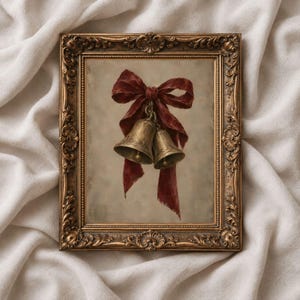 Può includere: Un dipinto incorniciato raffigurante due campane color ottone legate insieme da un nastro rosso scuro. L'opera è racchiusa in una cornice dorata decorata in stile antico con dettagli floreali e volute lungo i bordi.