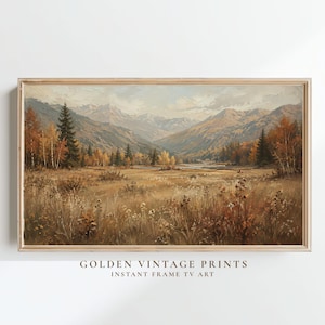 May include: A rectangular landscape print featuring a mountain valley scene with golden autumn foliage, evergreen trees, and a meadow of dried grasses. The text GOLDEN VINTAGE PRINTS INSTANT FRAME TV ART is printed in black below the artwork.