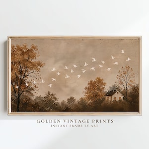 May include: A rectangular landscape print featuring a flock of white birds flying across a sepia-toned sky above a forest and a small house. The artwork is enclosed in a thin wooden frame. The text "GOLDEN VINTAGE PRINTS INSTANT FRAME TV ART" is visible.