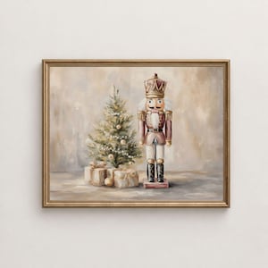 May include: A framed wall art print featuring a painted nutcracker figure standing next to a small decorated Christmas tree and wrapped gift boxes. The color palette consists of soft muted tones of beige, gold, and brown.