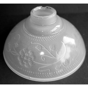 May include: A frosted glass lampshade with a floral and vine design. The shade has a rounded, bell-like shape with a decorative beaded border. The top opening is cylindrical. The design is etched into the glass, creating a subtle, elegant pattern.