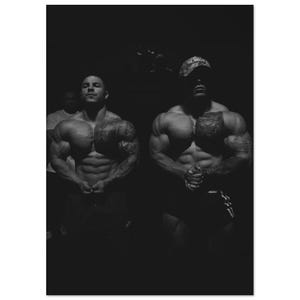 Könnte beinhalten: Schwarz-Weiß-Foto von zwei muskulösen Bodybuildern, die posieren. Sie haben Tätowierungen an Armen und Brust. Einer trägt eine Camouflage-Kappe. Das Bild ist dunkel und dramatisch.