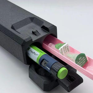 May include: A black rectangular carrying case containing a green and blue FlexPen insulin injector with a lime green dial. A pink sliding tray holds several BD sterile needle tips, each labeled 0.23mm x 4mm and 32G x 5/32 inches for medical use.
