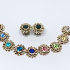 May include: A set of ten gold-toned body jewelry pieces with various colored gemstones. Each piece features a circular design with a single gemstone in the center.