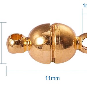 May include: A gold-colored magnetic clasp for jewelry making. The clasp is oval-shaped, measuring 11mm long, 5mm high, and 1mm thick. It features two loops for attaching to jewelry pieces and a magnetic closure in the center.
