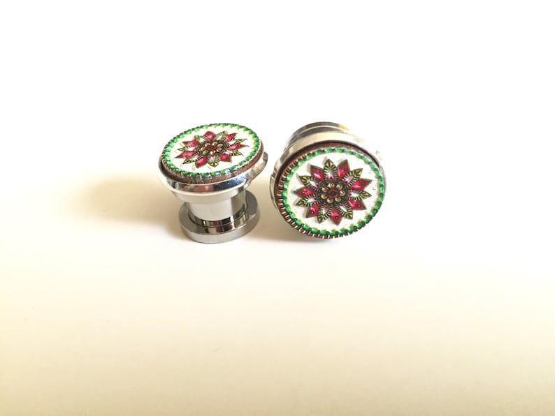 May include: Two decorative cabinet knobs with a floral design. The knobs have a silver base and a round top with a white background, a red and gold floral pattern, and a green border.