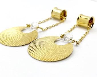 May include: A pair of gold-toned earrings with a fan-shaped design and a clear crystal bead hanging from a gold chain.