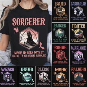 Könnte beinhalten: Schwarzes T-Shirt mit einem Sorcerer-Design, einer Burg-Illustration und dem Text "Maybe I'm born with it, maybe it's an arcane bloodline." Weitere Designs: Bard, Barbarian, Ranger, Fighter, Rogue, Warlock, Wizard, Druid, Cleric, Monk und Paladin.