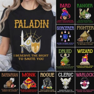 Può includere: T-shirt nera con grafica dorata "PALADIN" e un disegno di spada, scudo e croce. Sotto c'è il testo "I RESERVE THE RIGHT TO SMITE YOU". Sono presenti anche altri disegni di classe.