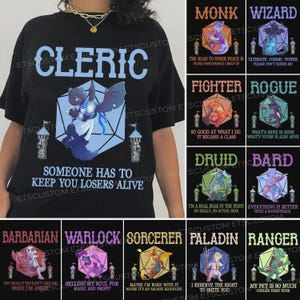 Puede incluir: Camiseta negra con un diseño de Clérigo que presenta una criatura parecida a un dragón dentro de un dado D20, con el texto "Alguien tiene que manteneros con vida, perdedores". Diseños adicionales para Monje, Mago, Luchador, Pícaro, Druida, Bardo, Bárbaro, Brujo, Hechicero, Paladín y Guardabosques.