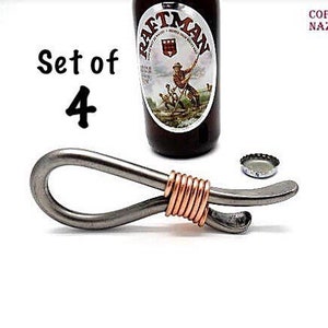 May include: Set of four silver bottle openers with copper wire accents. The openers are shaped like a loop with a bottle opener on one end.