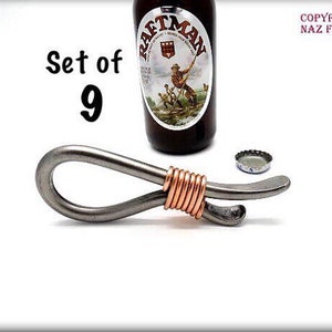 May include: Set of 9 silver bottle openers with copper wire accents. The bottle openers are shaped like a loop with a small hook on the end.