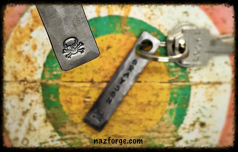 May include: Two metal keychains, one with a skull and crossbones design and the other with the text "nazforge.com".