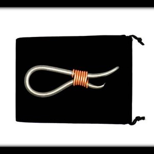 May include: A silver metal loop with a copper wire wrapped around the center. The loop is on a black velvet background.