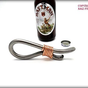 May include: A silver bottle opener with a copper wire wrapped around the handle. The opener is designed to open bottles with a twist-off cap.
