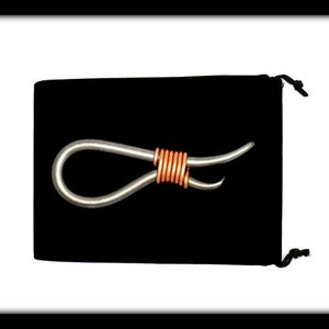 May include: A silver metal loop with a copper wire wrapped around the center. The loop is on a black velvet background.