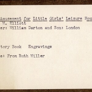 Pode incluir: Uma imagem em preto e branco de um cart&atilde;o de cat&aacute;logo de livro com o t&iacute;tulo "Amusement for Little Girls' Leisure Hours" de M. Elliott, publicado por William Darton and Son em Londres. O cart&atilde;o tamb&eacute;m indica que o livro &eacute; um livro de hist&oacute;rias com gravuras e foi comprado de Ruth Miller.